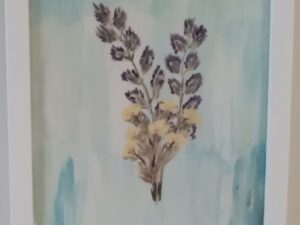 A watercolor painting of lavender flowers in a white frame.