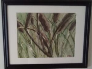 A painting of cattails in a black frame.