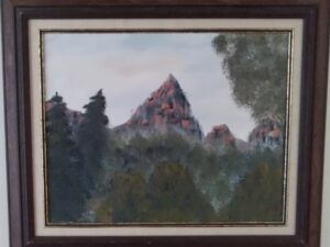 A painting of a mountain in a framed frame.