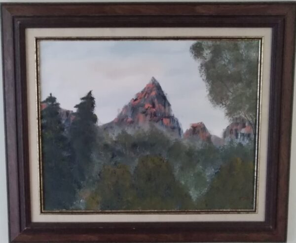 A painting of a mountain in a framed frame.