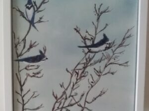 Three birds perched on a branch in a white frame.