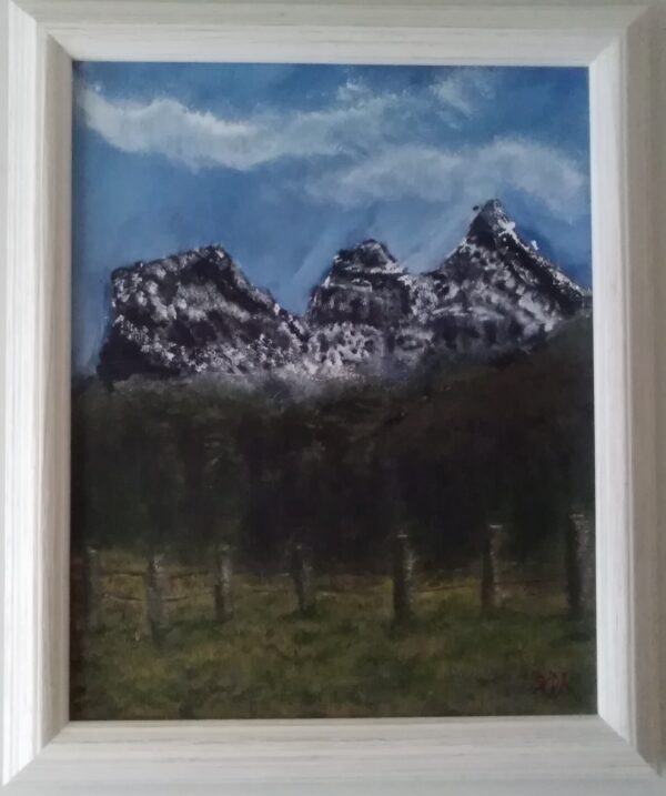 A painting of snowy mountains in a white frame.