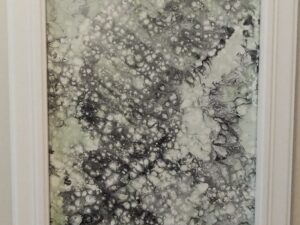 Black, green and white cell art painting in a frame