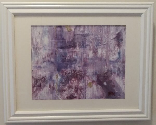 An abstract painting in a white frame on a wall.